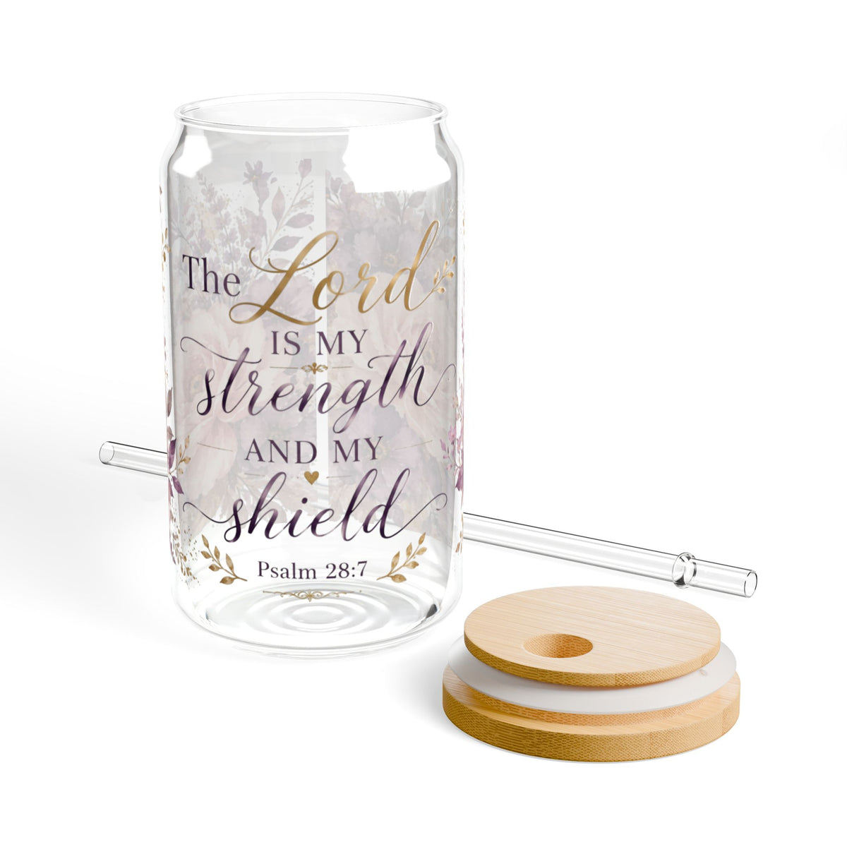 Clear glass can-shaped tumbler with floral print and the quote 'The Lord is my strength and my shield Psalm 28:7' in gold and dark lettering, shown with a clear glass straw and a wooden lid on a white background.
